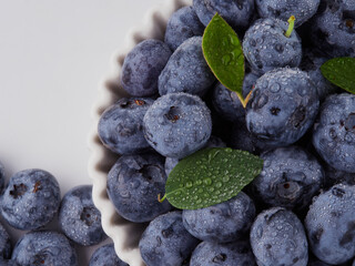 Blueberry fruit top view isolated on a white background, flat lay overhead layout with mint leaf, healthy design concept.