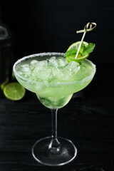 Glass of cold daiquiri cocktail on dark background