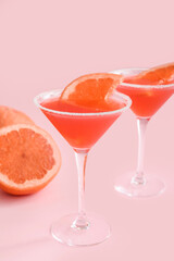 Glasses of Hemingway daiquiri cocktail and grapefruit on color background