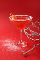 Composition with glass of Hemingway daiquiri cocktail and tree branch on color background