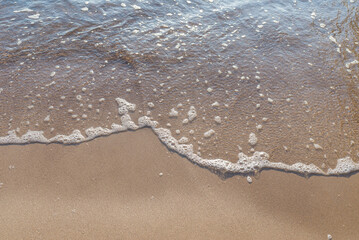 Soft wave of the sea on the sandy evening beach.Soft focus,blurred image.