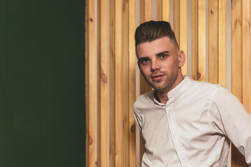 Portrait of a young unshaven man with a beautiful hairstyle
