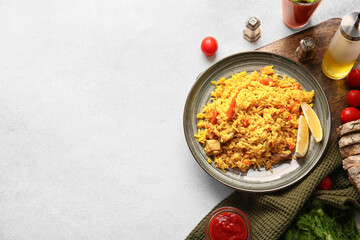 Plate with tasty pilaf on light background
