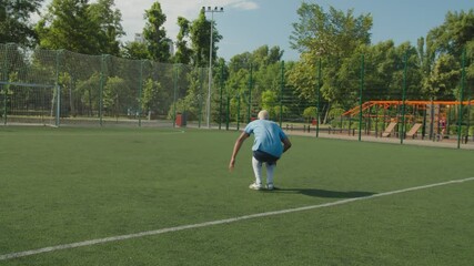 Handsome mixed race soccer player in sportswear getting cramp during football training game, while teammate helping to relieve cramping, stretching foot on football pitch at sunrise. - Powered by Adobe