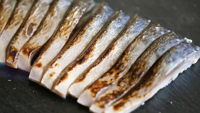 酢で〆た鯖をガスバーナーで炙っているクローズアップ動画。