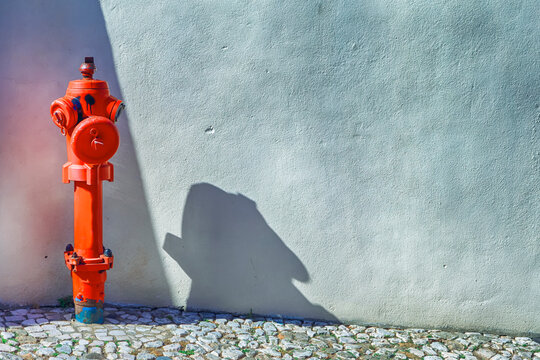 Closeup View of Old Styled Red Fire Cock Hydrant Against of Wall Located On One of The Streets in Portugal.