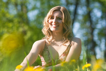 Naklejka na ściany i meble Young Woman Blond Female Summertime Resting on Green Meadow Outdoors With Positive Expression.