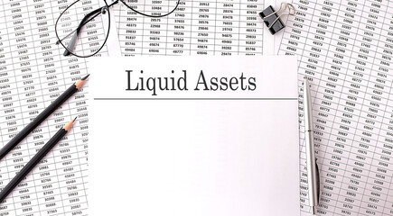 Paper with LIQUID ASSETS on a table on charts
