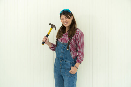 Females carpenter holding a hammer near white background