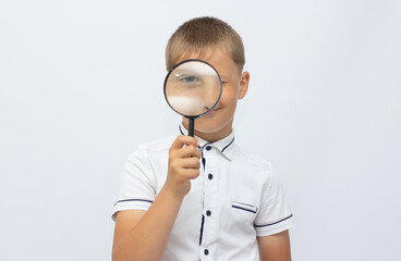 Closeup of a beautiful child looking through a magnifying glass loop over white