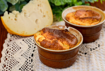 French baked cheese souffle in rameken on wood table
