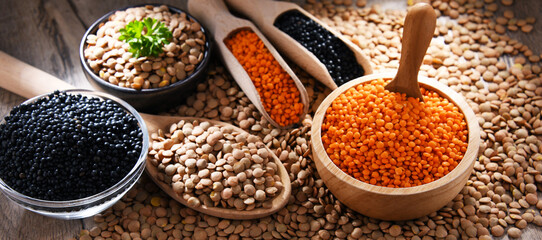 Composition with three sorts of lentils on wooden table