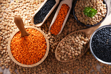 Composition with three sorts of lentils on wooden table