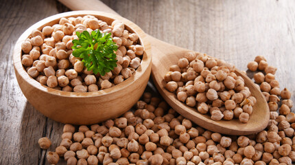 Bowl and spoon of chickpeas on wooden table