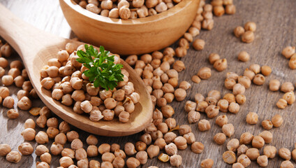 Bowl and spoon of chickpeas on wooden table