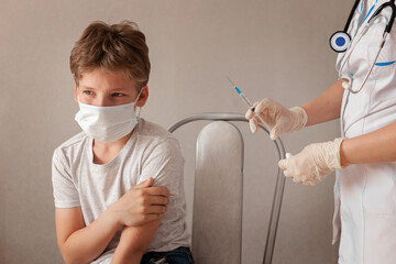 schoolboy medical mask crying, afraid injection, doctor standing rubber gloves, holding syringe....