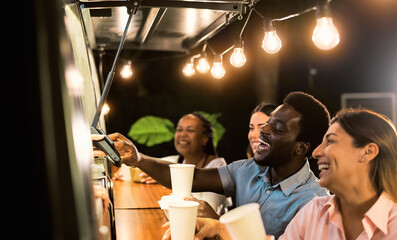 Happy multiracial people buying meal from food truck kitchen - Modern business and take away concept