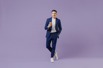 Fototapeta na wymiar Full size young successful employee business man lawyer 20 wear formal blue suit white t-shirt hold takeaway delivery craft paper brown cup coffee isolated on pastel purple background studio portrait