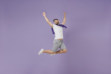 Fototapeta premium Full size body length young brunet man 20s wear white t-shirt purple shirt jump celebrate clench fists say yes isolated on pastel violet background studio portrait. People emotions lifestyle concept.