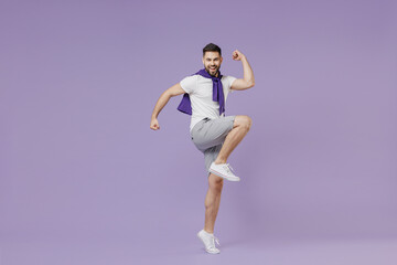 Fototapeta na wymiar Full size body length happy excited young brunet man 20s wear white t-shirt purple shirt doing winner gesture celebrating clenching fists say yes isolated on pastel violet background studio portrait