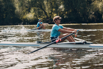 Sportsman single scull man rower rowing at competition boat regatta river - obrazy, fototapety, plakaty