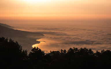 Beautiful sunrise with clouds above the sea. View from the mountain on the town. Peaceful scenery, inspiring nature.