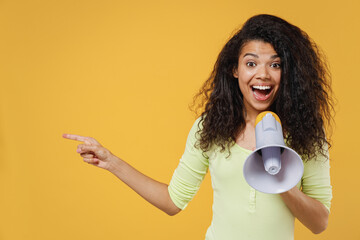 African american young woman 20s wears green shirt hold scream in megaphone announces discount sale...