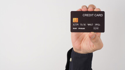 Hand is holding black credit card isolated on white background. Asian man hand.