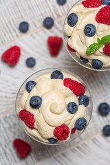 Top view of mascarpone whipped cream with berries - Italian dessert.  Vertical image.