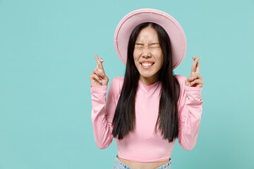 Happy young brunette asian woman 20s eyes closed wears pink clothes hat wait for special moment...