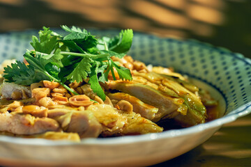 Salad with boiled chicken, cilantro, peanuts in hot soy sauce. Chinese cuisine.