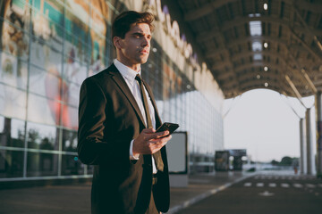 Bottom side view minded traveler businessman man in black suit go outside at international airport...