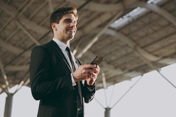 Bottom view happy fun traveler businessman young man wear black dinner suit stand outside at...