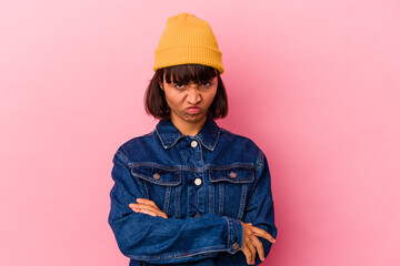 Young mixed race woman isolated on pink background frowning face in displeasure, keeps arms folded.