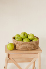 Modern home decor made from natural materials. Green ripe apples in a jute basket.Minimalistic concept.