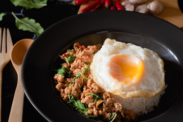 Thai traditional food , stirred-fired minced pork and chili mix with basil and fried egg on top steamed rice, hot and scipy