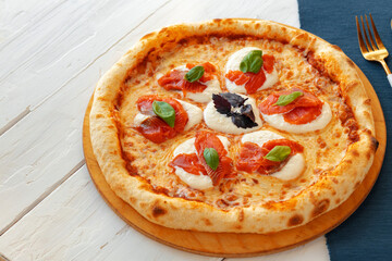 Hot pizza Margherita on white wooden table