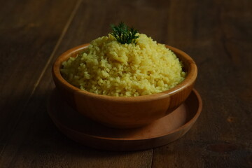 a bowl of  yellow rice on a wooden table 