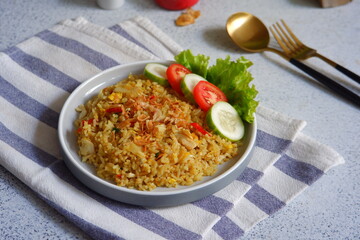 a plate of yellow fried rice with salad on the table 
