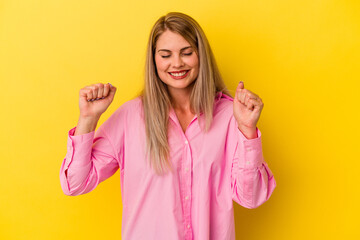 Young russian woman isolated on yellow background celebrating a victory, passion and enthusiasm, happy expression.