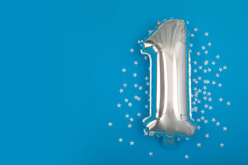 Silver balloon 1 on a blue background with confetti stars. Number One 1. Holiday Party Decoration...