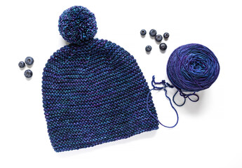 Blue Pom Pom knitted hat with hand dyed wool yarn on white background