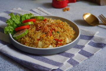 a plate of yellow fried rice with salad on the table 