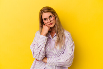 Young russian woman isolated on yellow background tired of a repetitive task.