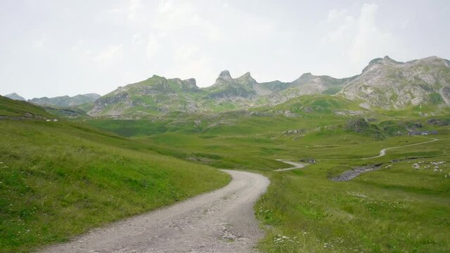 Col du Pourtalet Pass And Border In The Pyrenees Between France And Spain With Distant View Of Sheep Herd Grazing On Green Pasture. wide shot