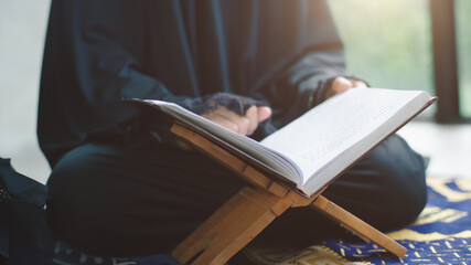 Portrait of an Asian Muslim women in a daily prayer at home reciting Surah al-Fatiha passage of the Qur'an in a single act of Sujud called a Sajdah or prostration