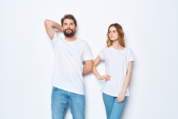 Fototapeta premium young couple in white t-shirts communication clothes jeans light background