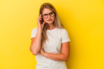 Young russian woman isolated on yellow background blows cheeks, has tired expression. Facial expression concept.