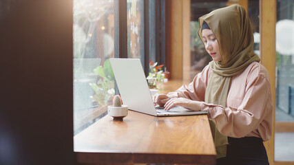 Upwardly mobile Asian Muslim business entrepreneur SME start up group of young man and women, discussing sale and marketing analysis, Asian Muslim SME teamwork e-commerce concept