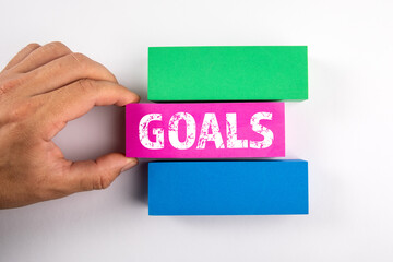 Goals. Colored blocks and a man's hand on a white background